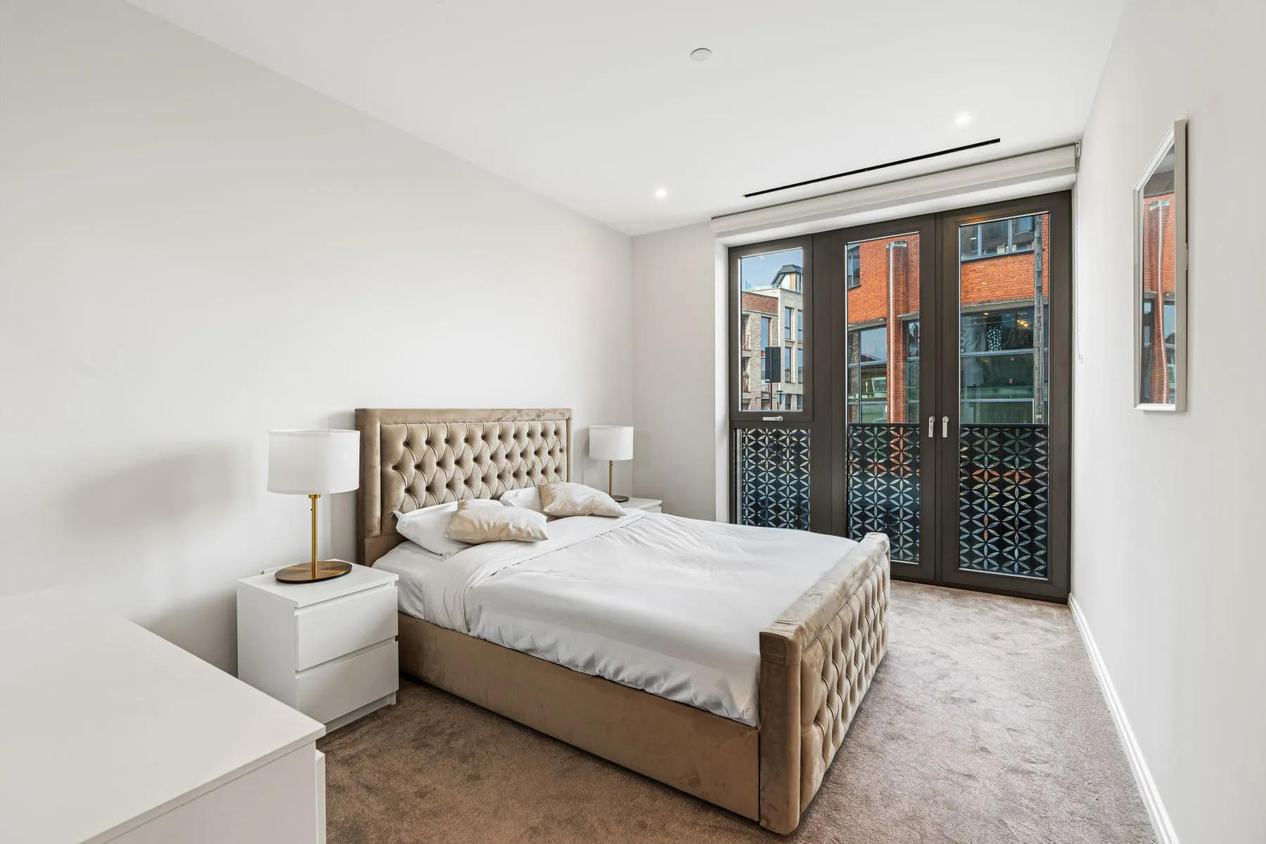 Second double bedroom with upholstered bed and development outlook